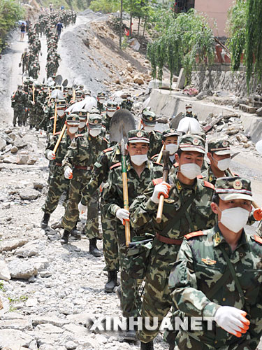 當日,在汶川地震重災區北川,解放軍,武警官兵和預備役救援人員一起冒